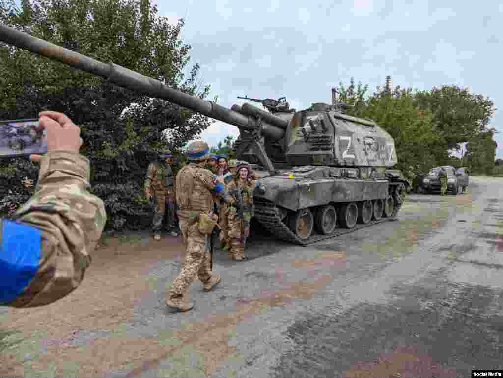 Українські війська збираються для колективного фото біля трофейної 2С19 «Мста», яку російська армія покинула під час хаотичного відступу. Самохідні гаубиці є одними з найпотужніших артилерійських знарядь Росії. Їхня вартість близько 1,5 мільйона доларів за одиницю