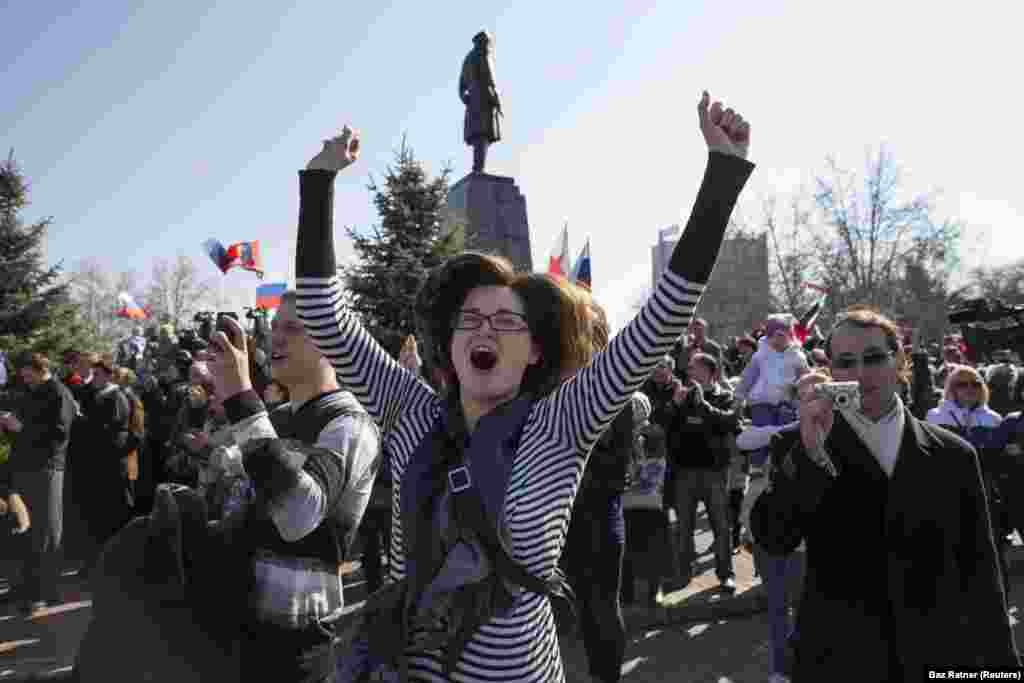 Женщина выражает радостные эмоции в Севастополе 18 марта, когда люди смотрят прямую трансляцию выступления Путина после результатов спорного референдума. Российский президент обратился к крымчанам как к «гражданам России»