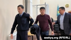 "Алаяқтық жасады" деген күдікке ілінген заңгер Өтепов (ортада) сотта. Орал, 24 наурыз, 2023 жыл.