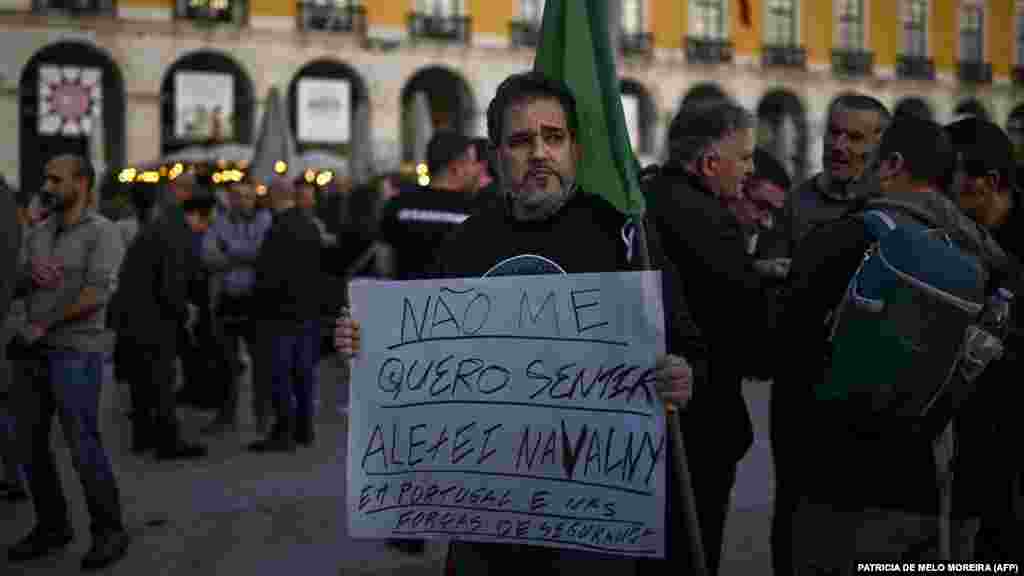 Egy rendőr egy „Nem akarom magam Alekszej Navalnijnak érezni Portugáliában és a portugál rendőrségben” feliratú plakátot tart a fizetésemelést követelő tüntetésen február 19-én Lisszabonban
