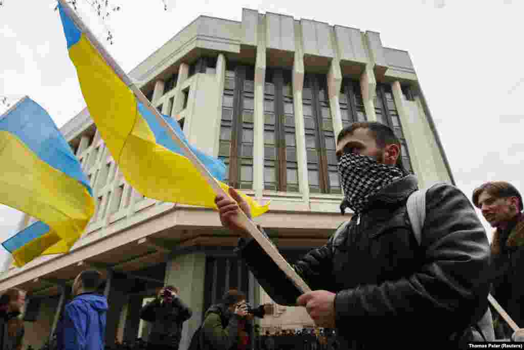 Проукраинские протестующие перед зданием парламента Крыма в Симферополе, 8 марта. Пророссийские силы прервали украинские новостные передачи и начали трансляцию российских государственных телеканалов. В это время несколько групп иностранных журналистов, работавших в Крыму, подверглись физическим атакам, а двое украинских журналистов были похищены 