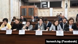 Билим берүү жана илим министри Догдуркүл Кендирбаева баштаган айымдар парламенттеги жыйынга катышып жатышат. Сүрөт иллюстрация үчүн колдонулду. 