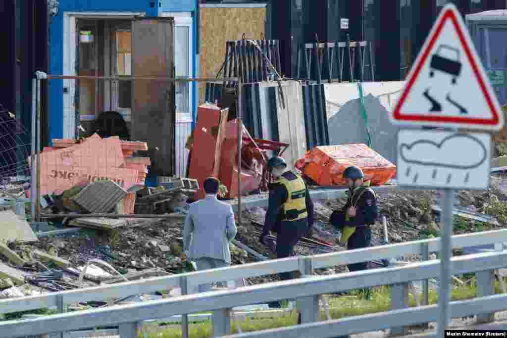 Members of the security services investigate the debris near the Moscow building that was reportedly struck by a drone. "A Kyiv regime attempt to carry out a terrorist act using two drones on objects on the territory of the city of Moscow was stopped," Russia's Defense Ministry said. "Two Ukrainian drones were suppressed and crashed. There are no casualties."