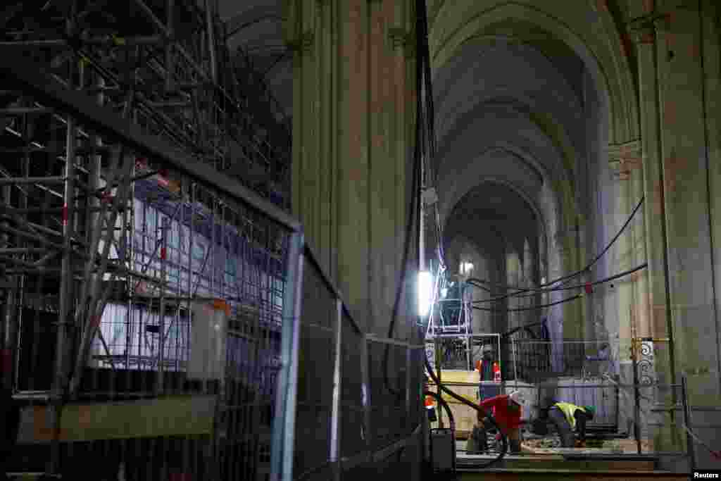 Punëtorët duke punuar në naos, pjesa qendrore e katedrales në formë kryqi e destinuar për të akomoduar pjesëmarrësit. Katedralja Notre Dame u shkatërrua nga zjarri në vitin 2019, që shkaktoi rrënimin e saj, ndërsa punimet për rindërtimin vazhdojnë një vit para rihapjes së saj për publikun, në Paris, Francë, 8 dhjetor 2023.