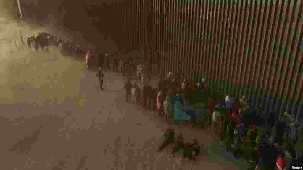 Një pamje me dron tregon emigrantët në radhë që përballen me mot të ftohtë dhe me erë derisa presin të dorëzohen te zyrtarët e imigracionit pasi kanë kaluar kufirin, Teksas, SHBA, më 25 mars 2024.