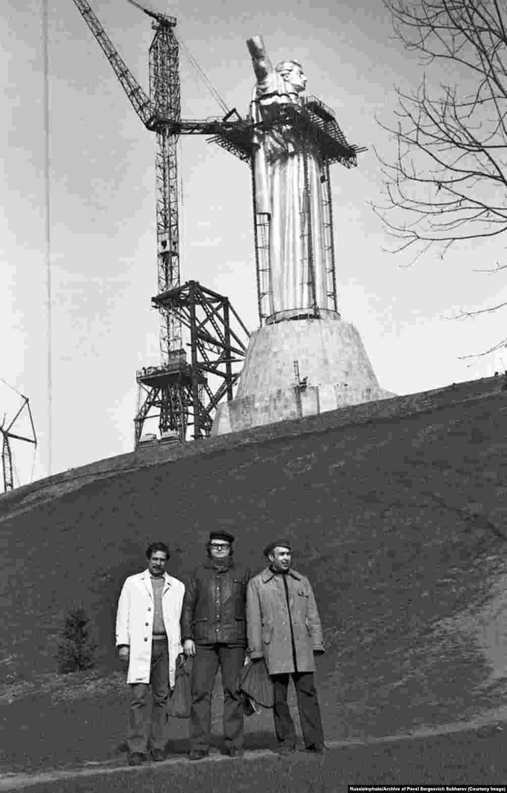 Muškarci poziraju ispred Spomenika Domovini tokom njegove izgradnje u martu 1981. Izgradnja statue sa čeličnim okvirom počela je 1979. godine, a završena je 1981. godine.