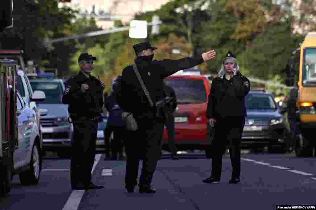 Police officers secure an area outside a damaged nonresidential building on Komsomolsky Prospekt after a reported drone attack. 