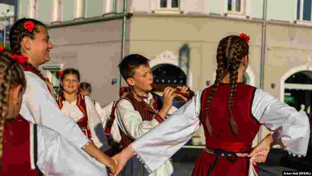 Plesači u tradicionalnoj crveno-crnoj nošnji. 