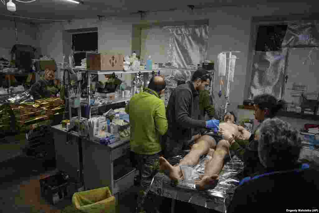 Mjekët duke trajtuar ushtarët e plagosur ukrainas në sallën e operacionit në një spital fushor në Bahmut më 26 shkurt.