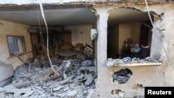 Palestinezët duke e shikuar një shtëpi të rrënuar nga një sulm izraelit në Rafah, në jug të Rripit të Gazës, 8 shkurt 2024.