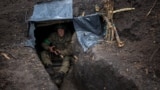 Український піхотинець 57-ї окремої мотопіхотної бригади сидить в окопі на сході України 