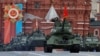 Реактивные самолеты Су-25 выпускают дым в цветах государственного флага над собором Василия Блаженного во время военного парада в российский "День Победы". Москва, 9 мая 2024 года