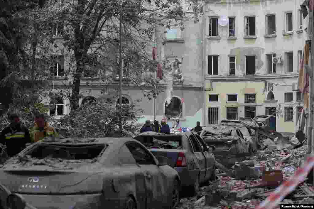 Punonjësit e shpëtimit në vendin e ngjarjes në një rrugë të mbuluar me rrënojat e objekteve. Kryetari i bashkisë së Lvivit, Andriy Sadovyi, tha se rreth 60 apartamente dhe 50 makina u dëmtuan nga ky sulm.