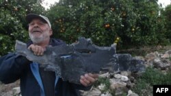 Një burrë mban një copë rakete pas sulmeve ajrore izraelite në Al Qulaylah, në periferi të qytetit Tyre, në jug të kryeqytetit libanez, Bejrut. 7 prill 2023.