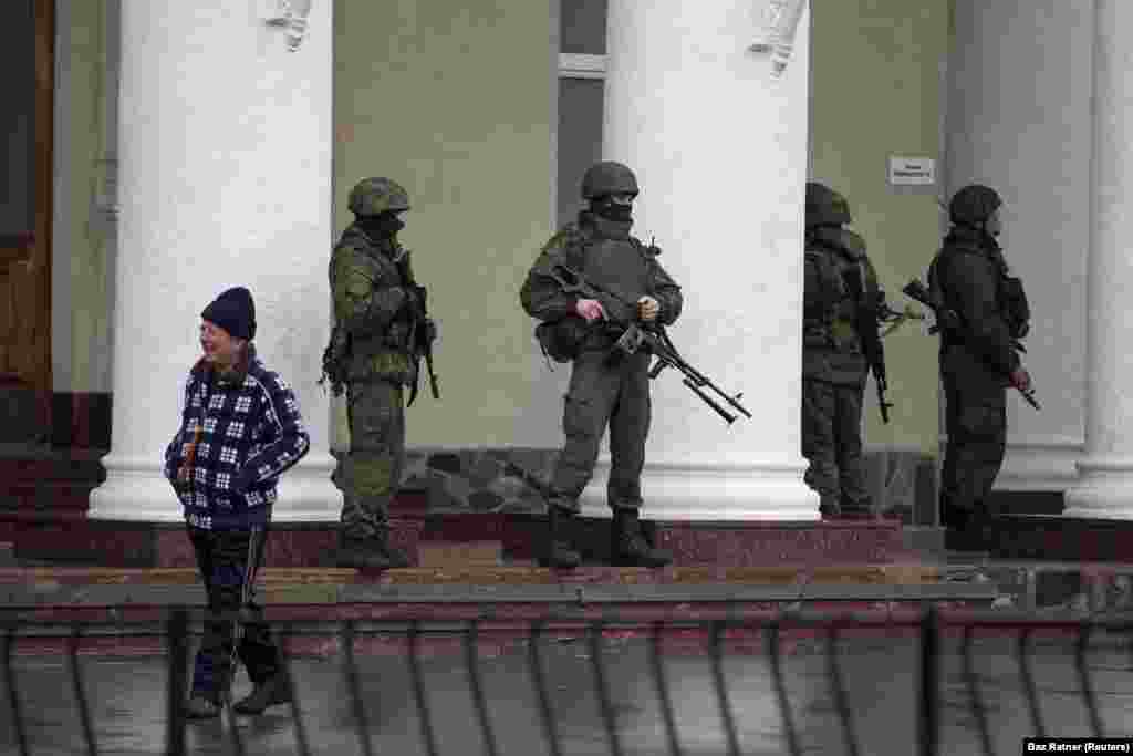Российские военные без опознавательных знаков возле аэропорта Симферополя, 28 февраля. Военные из России, «зелёные человечки», заняли стратегические объекты по всему Крыму. Кремль первоначально утверждал, что это была местная «самооборона», но позже признал, что на полуострове были профессиональные российские военные 