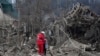 Медработник успокаивает женщину среди руин домов в Запорожье. Последствия российской ракетной атаки 22 марта 2024 года