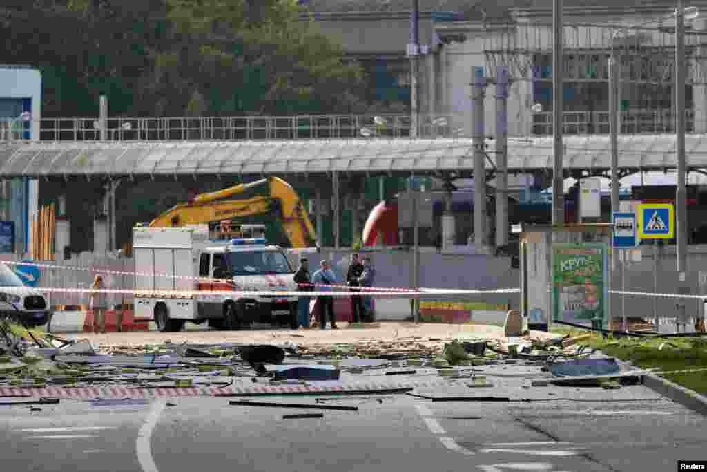 Members of the security services investigate the site where the debris landed after the reported drone attack. The attack came a day after Kyiv vowed to "retaliate" for a Russian missile attack on the Black Sea port of Odesa. 