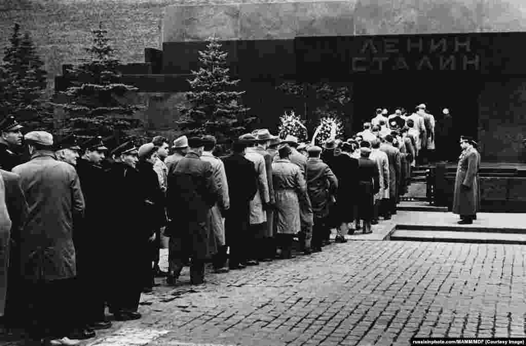 На фотографии 1958 года имена Ленина и Сталина у входа в мавзолей на Красной площади. В 1961 году, на фоне «десталинизации» и осуждения массовых убийств при Сталине, его тело было вынесено из мавзолея.