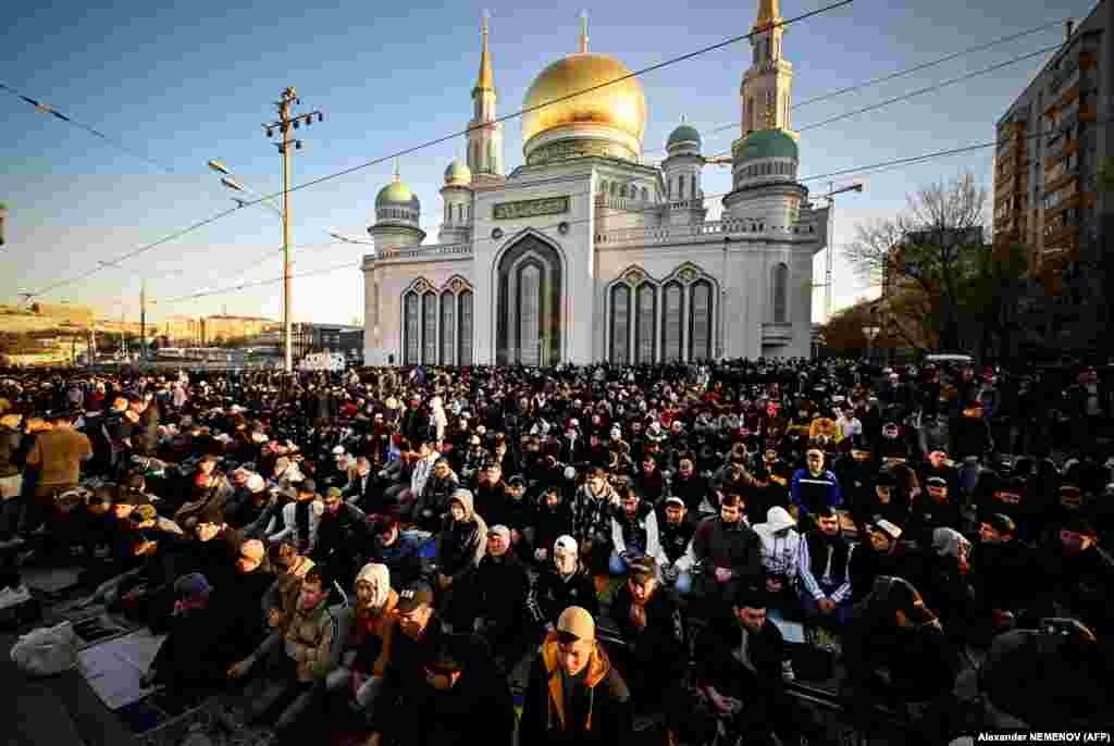 Верующие в первый день Ораза-айта молятся возле Центральной мечети в Москве. Поскольку в исламе используется лунный календарь, появление луны определяет начало праздника