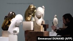 Un vizitator face o fotografie lucrărilor artistului român Constantin Brâncuși în timpul avanpremierii retrospectivei desfășurate la Centrul Pompidou. 26 martie 2024. 