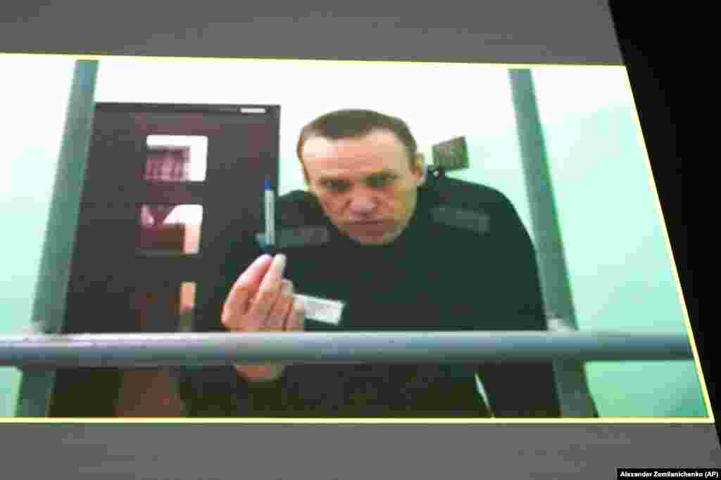 Лидер российской оппозиции Алексей Навальный на экране монитора. Его подключили к заседанию в Верховном суде по видеосвязи из колонии в Мелехово Владимирской области, 22 июня 2023 года. Навальный пытался оспорить тюремные правила, которые, по его словам, позволяют администрации учреждения не давать ему канцелярские принадлежности и ручки, тем самым нарушая его право подавать жалобы на действия сотрудников колонии. AP/Alexander Zemlianichenko