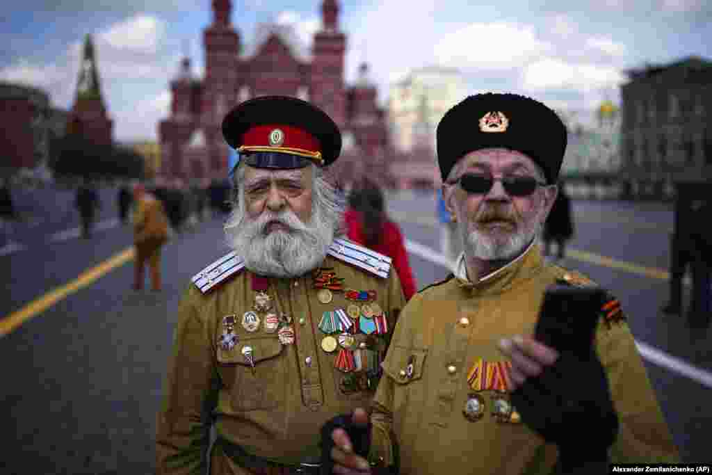 Moscova, Federația Rusă, 22 aprilie. Doi bărbați în uniforme de cazaci își fac o fotografie după ce au vizitat, pentru a marca a 154-a aniversare a lui Lenin, mausoleul acestuia din Piața Roșie de la Moscova.