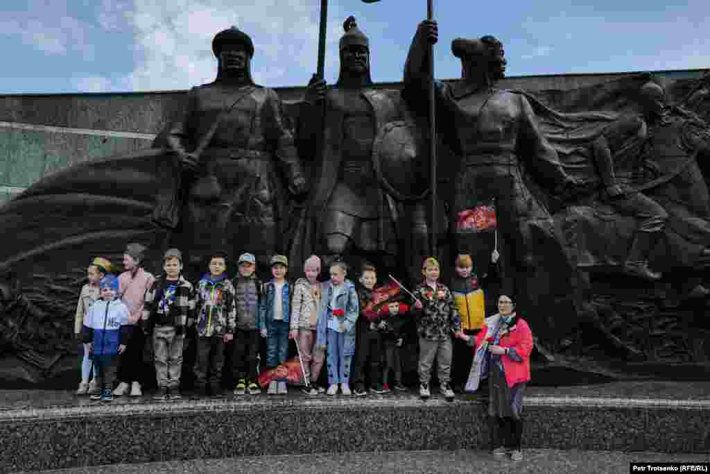 Ескерткіш алдында суретке түсіп жатқан балалар. 