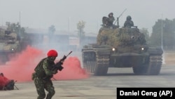 A Taiwanese soldier reacts as a tank approaches during January military drills simulating a military invasion.