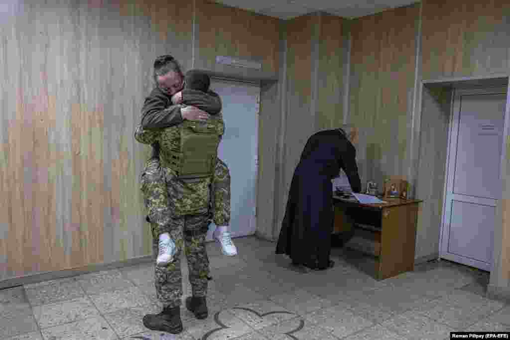Супруги обнимаются после обмена брачными обетами в Броварском районе Киевской области на фоне наступления российской армии на Киев. Молодые, пожелавшие остаться анонимными, впервые встретились на востоке Украины в 2015 году, когда вместе воевали против поддерживаемых Россией сепаратистов "ДНР" и "ЛНР", но серьезные отношения у них начались после новой случайной встречи уже во время полномасштабного вторжения России в Украину в 2022 году.