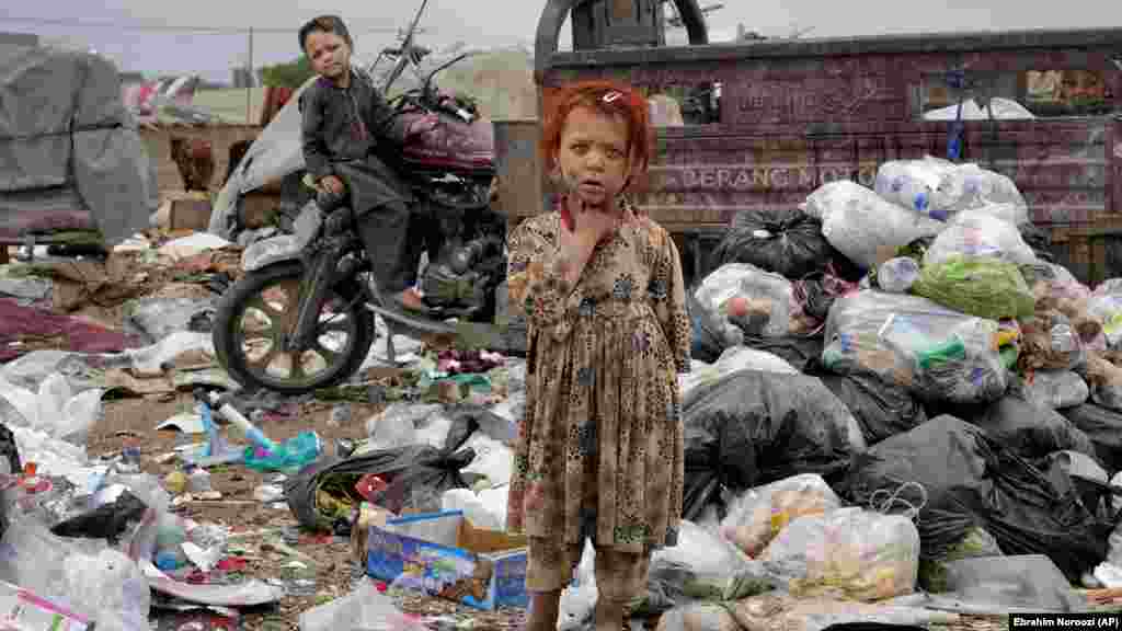 Dy fëmijë afganë duke qëndruar mes grumbujve të mbeturinave pranë shtëpisë së tyre në Kabul. Bruto Produkti i Brendshëm i Afganistanit është vështirë të matet, por vlerësohet të ketë rënë me gati 20 për qind që kur talibanët u kthyen në pushtet, duke rrezikuar jetën e miliona njerëzve në vendin tashmë të varfër. 