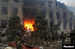 Membri ai trupelor pro-ruse, inclusiv luptători ceceni, în fața clădirii administrative a uzinei Azovstal din Mariupol, 21 aprilie 2022.