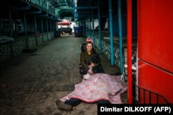 O femeie plânge lângă cadavrul soțului ei ucis într-un bombardament rusesc asupra orașului ucrainean Herson, pe 24 decembrie 2022.