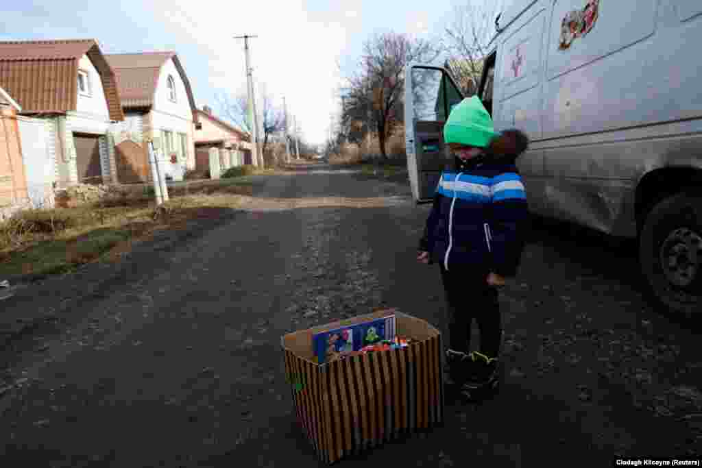 Тем временем 4-летний Тимур рассматривает коробку с его подарками. 