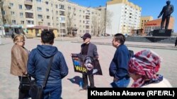Юрист Ербол Аккужанов на площади имени Ауэзова в городе Семей держит плакат надписью: «No war» («Нет войне»). Семей, 15 апреля 2022 года