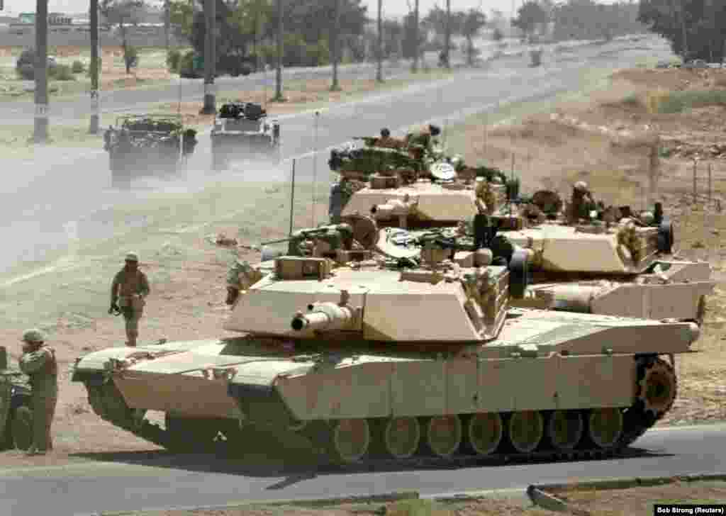 Танки M1A1 «Абрамс» американских морпехов занимают оборонительные позиции во время перестрелки возле главного контрольно-пропускного пункта в Эль-Фаллудже, Ирак, 24 июня 2004 года. Экспортная версия «Абрамса» используется в армиях Австралии, Египта, Ирака, Кувейта, Польши и Саудовской Аравии 