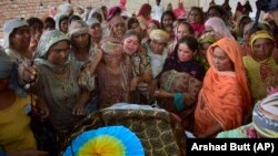Women mourn around the body of a man who died when the roof of his house collapsed due to heavy rains on the outskirts of Quetta on July 5.