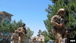 Afghan security officials take positions during a gunbattle between Taliban suicide bombers and Afghan security officials in Lashkar Gah, the provincial capital of Helmand province, May 13, 2015