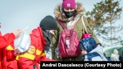 Voluntari SMURD oferă alimente și dulciuri refugiaților care trec în România prin vama Siret în data de 26 februarie 2022, la două zile de la izbucnirea războiului.
