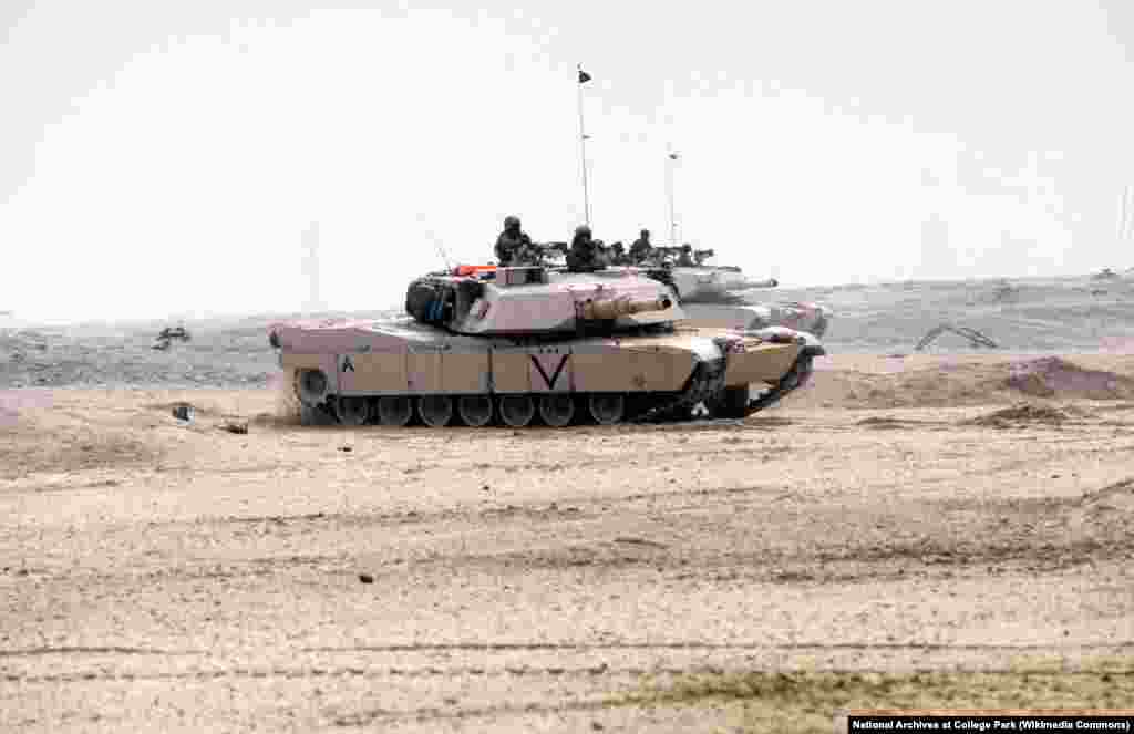 Два боевых танка M-1A1 «Абрамс» американских морпехов движутся по пустыне во время наземной фазы операции «Буря в пустыне», 24 февраля 1991 года 