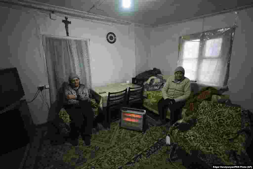 Dy gra të moshuara duke u ngrohur me një nxehëse me energji elektrike në Stepanakert. &nbsp;