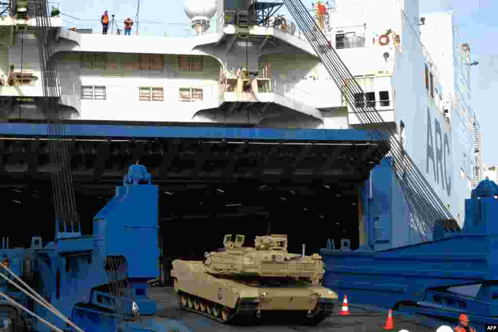 Военнослужащие разгружают танки M1 «Абрамс» в Бремерхафене, Германия, 21 февраля 2020 года. Марк Хертлинг, бывший командующий сухопутными войсками США в Европе, предположил, что немецкие танки «Леопард», которые будут поставлены в Украину, могут оказаться на полях сражений уже в марте. Американские танки, нуждающиеся в дополнительной материально-технической поддержке, могут появиться там как минимум через восемь месяцев 