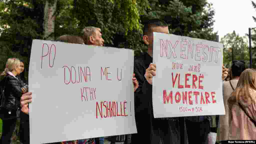 Disa nxënës duke mbajtur pankarta me mbishkrime "Nxënësit nuk janë vlerë monetare" etj. 