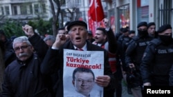 Një burrë mban një poster me fotografinë e kryetarit të Stambollit, Ekrem Imamoglu, gjatë një proteste në Stamboll, Turqi, më 9 prill 2025, kundër arrestimit të Imamoglut.