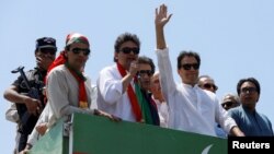 Imran Khan waves as he travels on a vehicle to lead a protest march to Islamabad in Mardan on May 25.