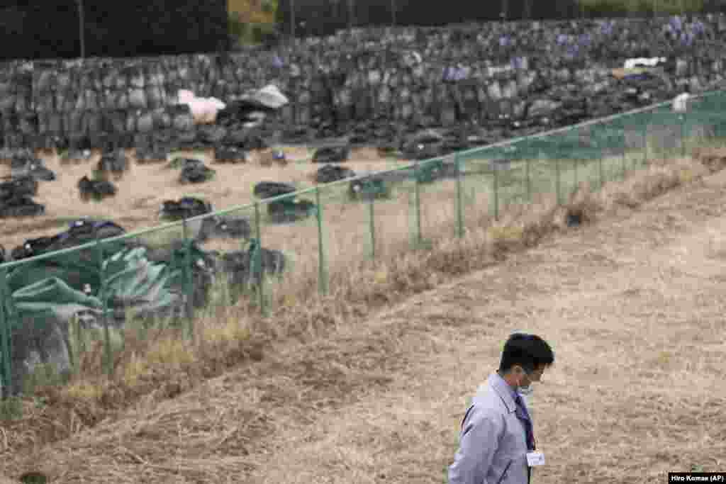 Yuya Hatakeyama, një zyrtar në qytetin Tomioka, ecën pranë një zone ku janë mbledhur mbetjet, që potencialisht janë radioaktive, më 26 shkurt, 2021. Ai ishte 14-vjeçar kur ndodhi katastrofa në Fukushima dhe ishte detyruar që të evakuohej. Tani, ai është 24 vjeç dhe po ndihmon në rindërtimin e komunitetit dhe që banorët e këtij qyteti të ribashkohen.&nbsp; &nbsp;
