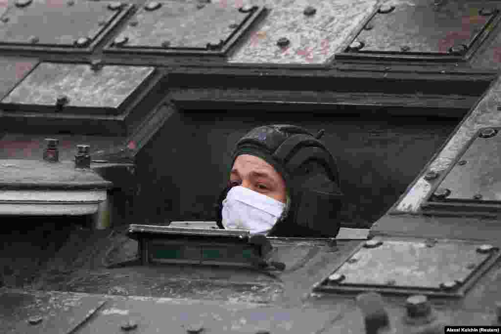Руски војник во заштитна маска излегува од воено возило за време на пробата за годишните прослави на Денот на победата. На настанот во Екатеринбург се очекува да има 13 авиони и девет хеликоптери.