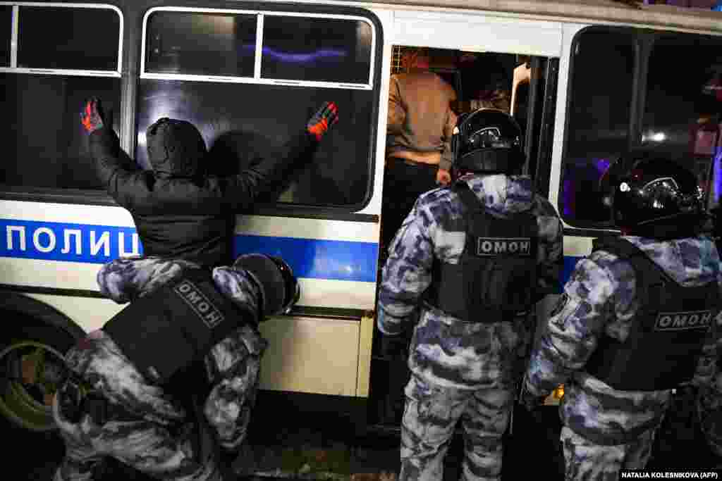 Një zyrtar policor kontrollon një person të ndaluar më 3 shkurt në qendër të Moskës.