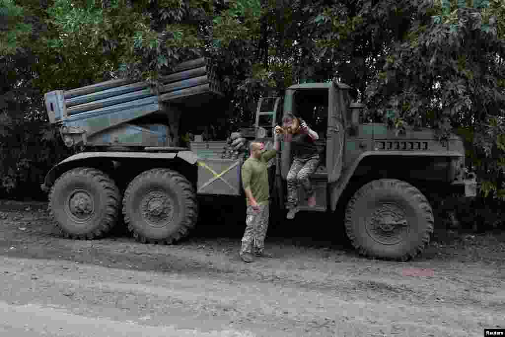 Tetyana Dovhopola is helped by her fellow soldier and husband, Andriy Dovhopoliy, as she jumps out their squad's BM21 Grad multiple-rocket launcher at a position near a front line in Ukraine's Mykolayiv region on September 16.