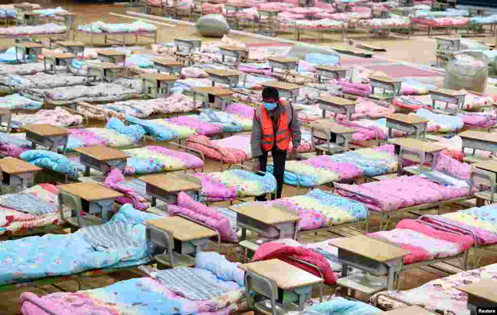 A worker sets up beds at the Hongshan Stadium in Wuhan, which has been converted into a makeshift hospital.