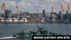 A Russian Navy ship passes the cargo seaport of Mariupol, an occupied Ukrainian city on the Sea of Azov, in June 2022.